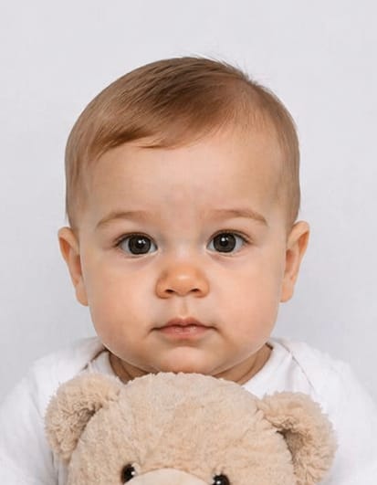 Baby passport photo example showing infant holding a toy, which is not allowed under UK passport photo rules
